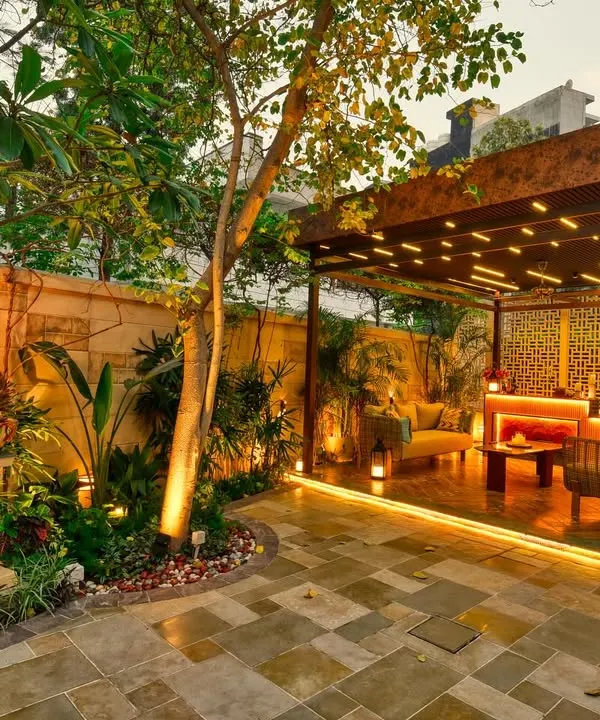 This backyard is now a stunning retreat for relaxation and entertainment. The custom pergola with integrated lighting creates a warm and inviting lounge area, while the surrounding greenery and stone pathways complete the sanctuary feel.