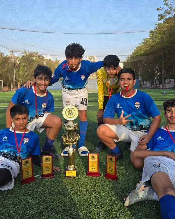 Our U15 team celebrating a major tournament win against other top academies in the city, surrounded by their trophies and medals.