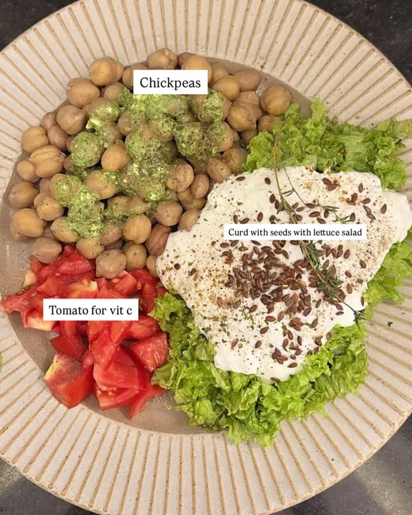 A perfectly balanced plate. This client meal features chickpeas for protein, fresh tomatoes for vitamin C, and curd with seeds over lettuce for probiotics and healthy fats. This is how we nourish the body.