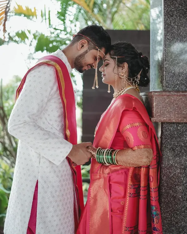 The quintessential Maharashtrian bride and groom. Her look is complete with the traditional headpiece, green bangles, and a makeup style that is both classic and radiant.