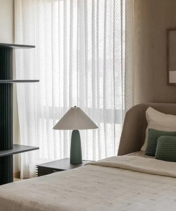 A guest bedroom in the Aikaa show villa in Hyderabad. We focused on understated luxury, using a palette of soft greens and beiges, layered textures, and clean lines to create a welcoming and serene space.