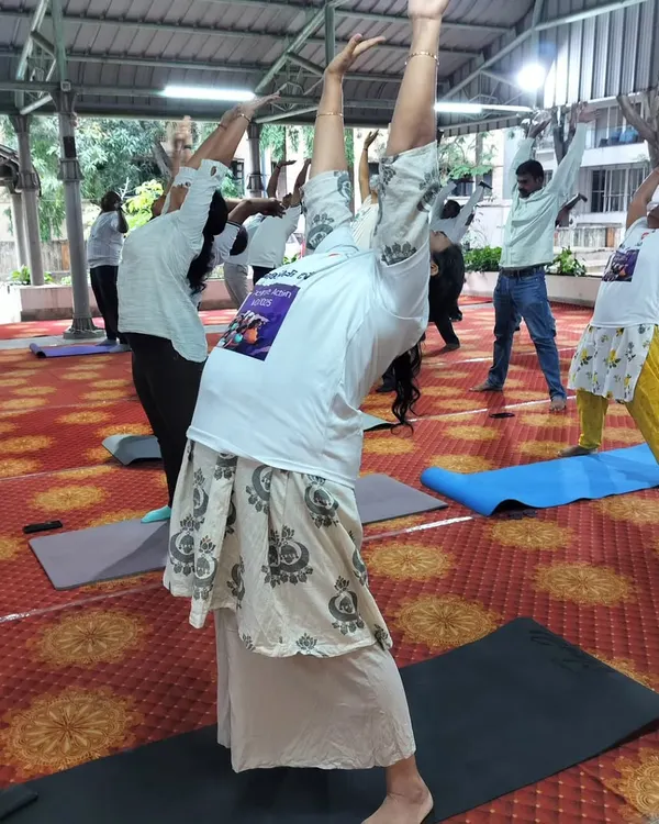 I lead a large group of employees through an energizing backbend during a corporate wellness session. This demonstrates my ability to manage and engage large teams, ensuring everyone participates and benefits, regardless of the group size.