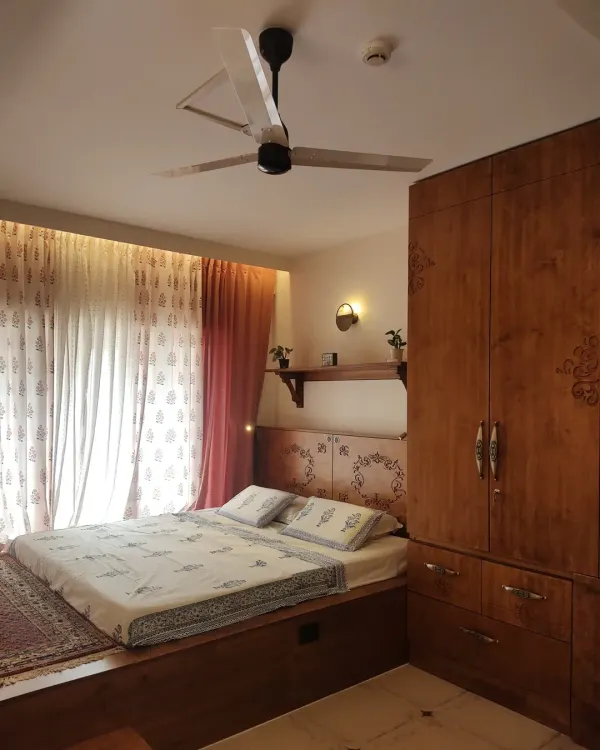 A full view of the master bedroom from #TheSampadaHome, showing how the custom platform bed, carved headboard, and matching wardrobe create a cohesive and elegant wooden interior.