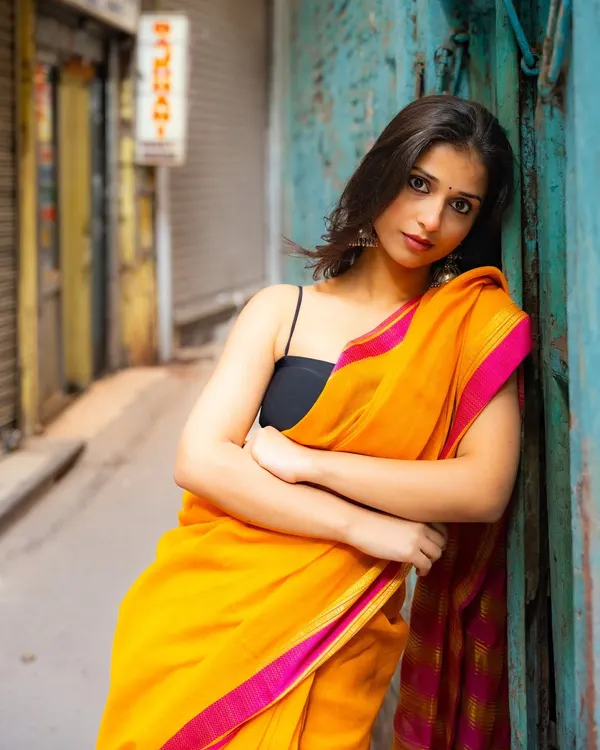 Finding a quiet, colorful alley in Old Delhi. The contrast between the bright yellow saree and the weathered blue door creates a stunning visual.