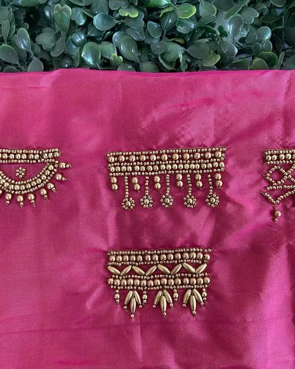 A sampler of different Aari embroidery border designs on pink silk fabric. These patterns are perfect for sleeve hems, necklines, or the edges of a dupatta.