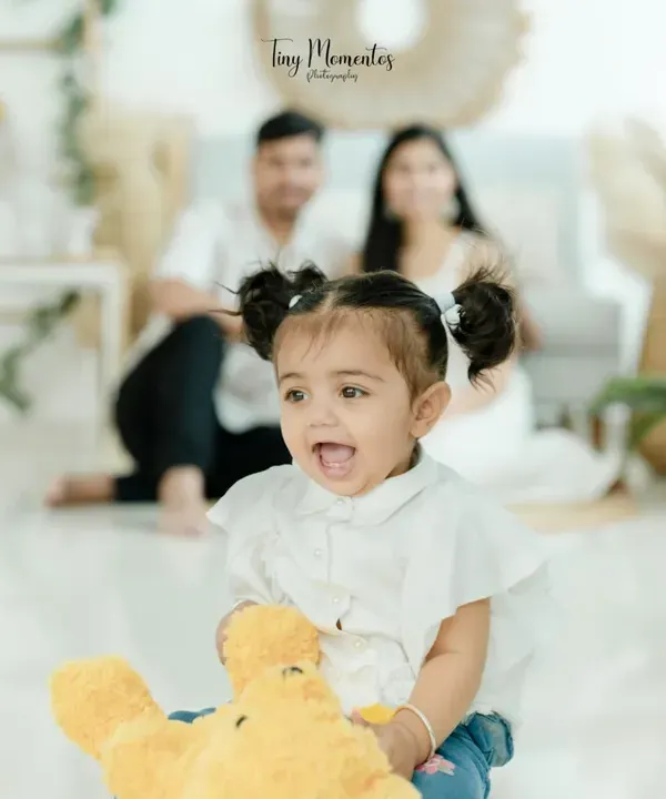 I believe the most beautiful family portraits happen in the moments between poses. This little one's pure, unscripted joy, with her loving parents softly in the background, is the kind of magic I strive to capture in every session.