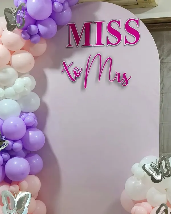 A close up of our popular 'Miss to Mrs' arched backdrop. The crisp lettering stands out against the soft pink panel, while the organic balloon garland with silver butterfly accents adds a touch of whimsy. This is a fantastic choice for a daytime bridal shower.