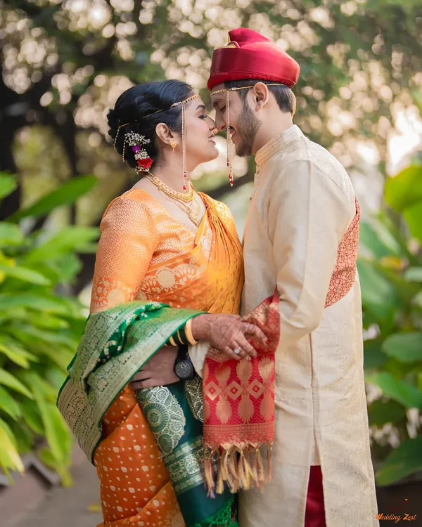An intimate moment between the bride and groom, showcasing the traditional Maharashtrian mundavalya and their coordinated wedding attire.