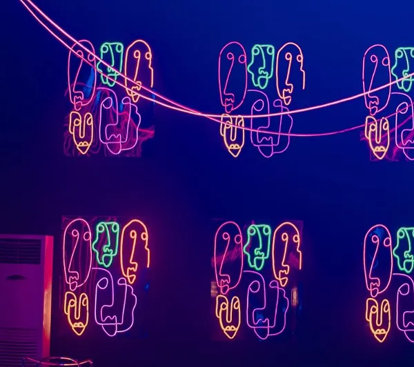 We used custom neon signs with abstract face motifs to decorate the walls. The multi-colored lights created a vibrant, artistic, and energetic atmosphere, perfect for a modern party.