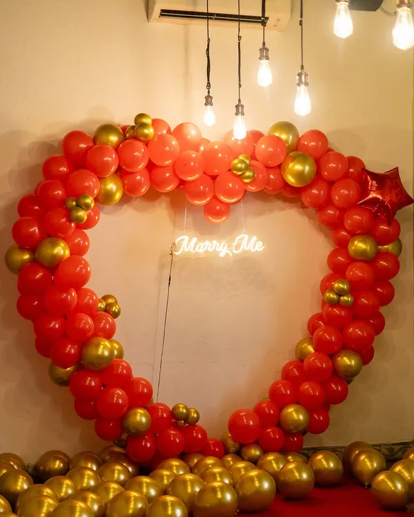 The perfect setting to pop the big question. We created this large heart-shaped balloon arch in red and gold with a 'Marry Me' neon sign to make the moment truly unforgettable.
