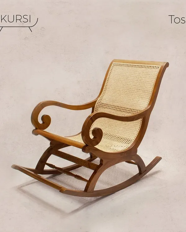 The 'Toshi' rocking chair, seen here in a studio setting. Its elegant curves and handwoven rattan back are a tribute to vintage design, re-imagined to offer timeless comfort.