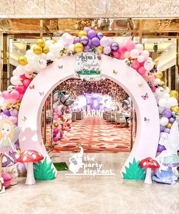 A grand entrance to an enchanted fairyland. This circular arch, adorned with pastel balloons and flowers, framed a magical pathway leading guests into Aarṇa's first birthday celebration.