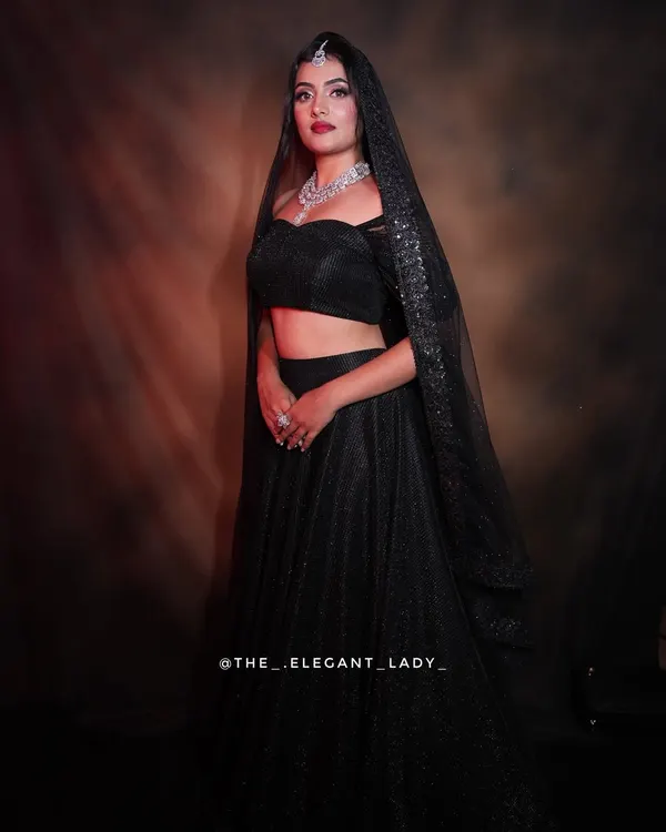 A dramatic and glamorous look featuring a stunning multi-layered CZ necklace set. Paired with a black lehenga and a sparkling dupatta, this is the perfect statement for a reception.