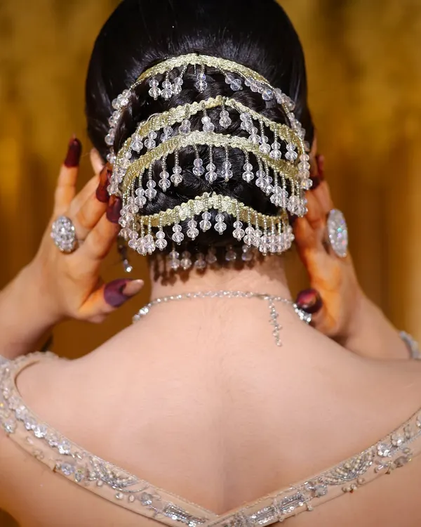 A close-up of an intricate bridal bun with beautiful beaded accessories. I teach you how to create clean, elegant hairstyles that last all day.
