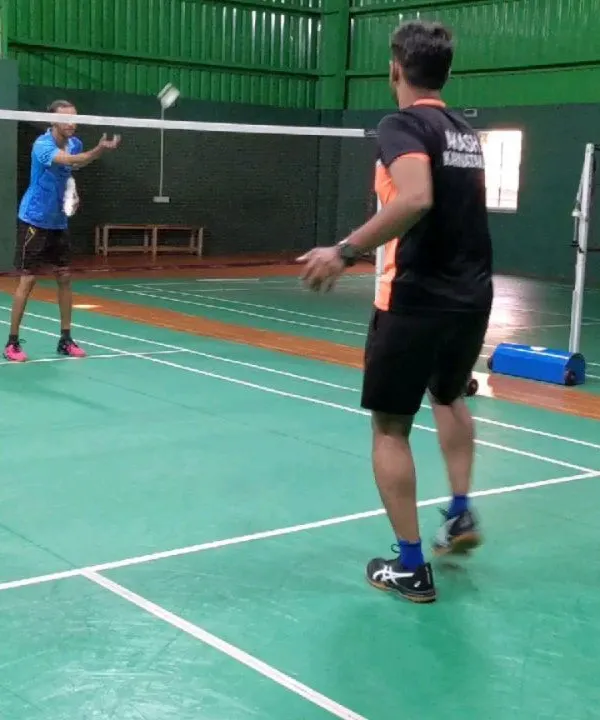 A coach provides one on one instruction during a practice session. I ensure players receive personalized feedback to help them master basic badminton strokes and improve their game.