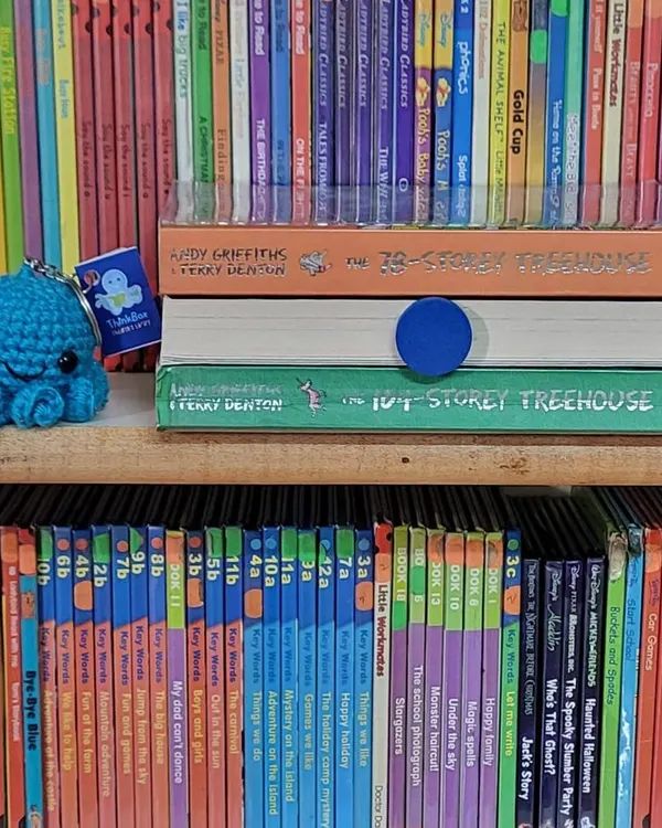 A peek at our shelves, featuring the hilarious "Treehouse" series and a cute handmade octopus keychain. Our library is filled with treasures waiting to be discovered.