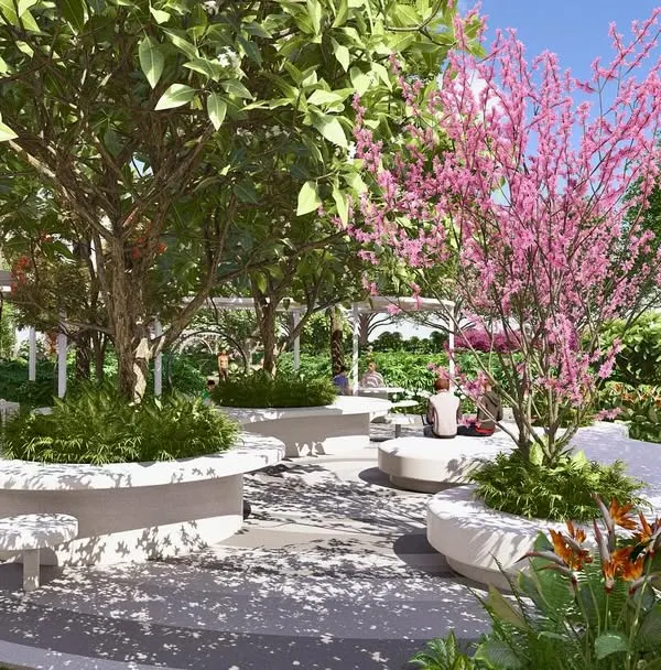 This seating plaza in the Kriya Villa development features curved, built-in benches nestled under flowering trees, creating an intimate and beautiful space for community interaction.