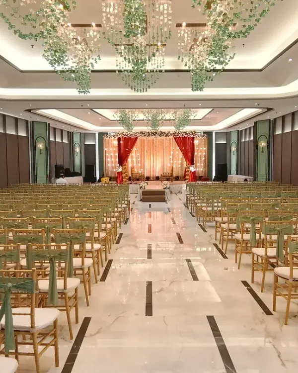 A complete transformation of a banquet hall for a wedding ceremony. We designed the stage with a red and gold backdrop, arranged elegant guest seating, and installed beautiful hanging floral chandeliers from the ceiling.