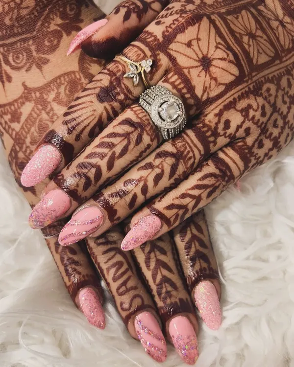 A gorgeous set for a bride, perfectly matching her beautiful henna. These long, almond-shaped nails feature a soft pink glitter base that adds a delicate sparkle for the big day.