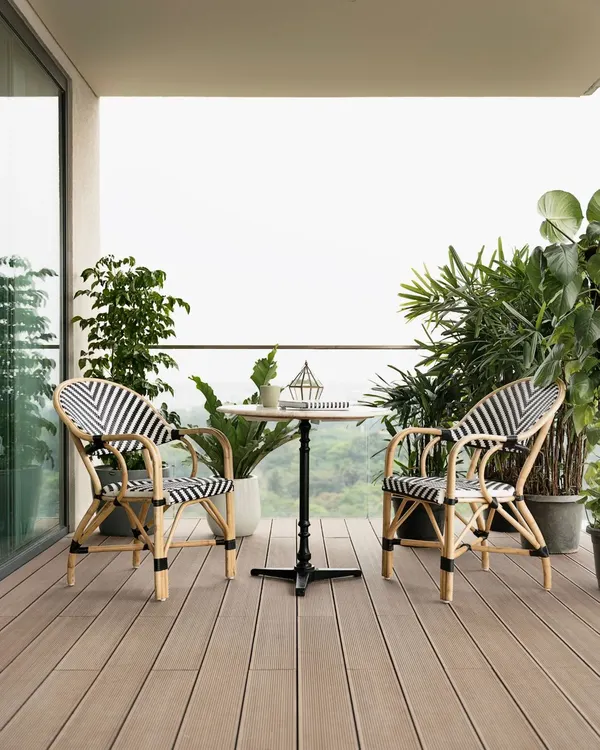 This balcony is the perfect spot to relax and enjoy the view. I chose these comfortable and stylish black-and-white bistro chairs and a small cafe table to create an inviting outdoor lounge area, surrounded by lush plants.