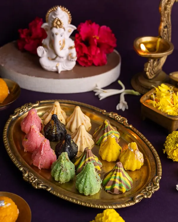 A colourful platter of assorted modaks for Ganesh Chaturthi. I used a brass thali and a Ganesha idol in the background to create a devotional and festive atmosphere.