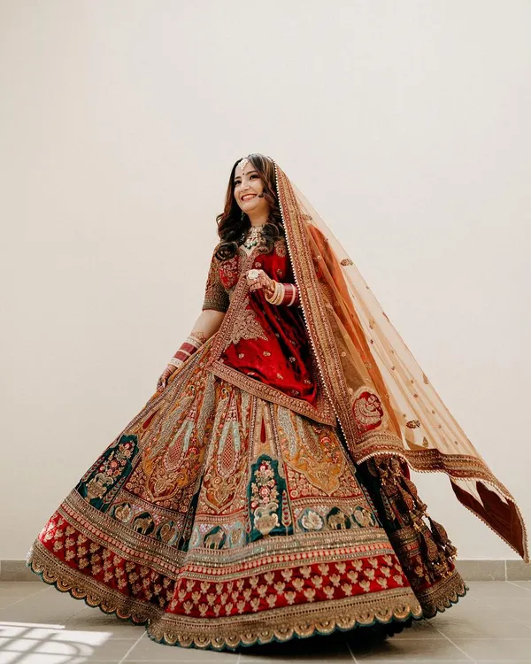 A full-length shot of the bride twirling in her magnificent multi-colored lehenga, a picture of pure grace and happiness.