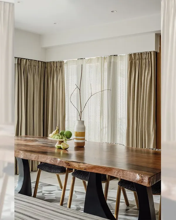 This live-edge dining table, made from a single slab of wood, is the centerpiece of this dining area. The natural grain of the wood is preserved and highlighted, while the modern black metal base provides a strong contrast. It’s a perfect example of how I blend raw, organic materials with contemporary design.