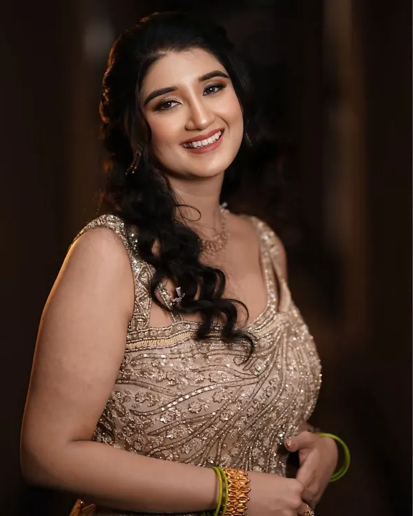 A soft and romantic engagement makeup look. The focus is on glowing skin, gentle waves in the hair, and a natural lip color.