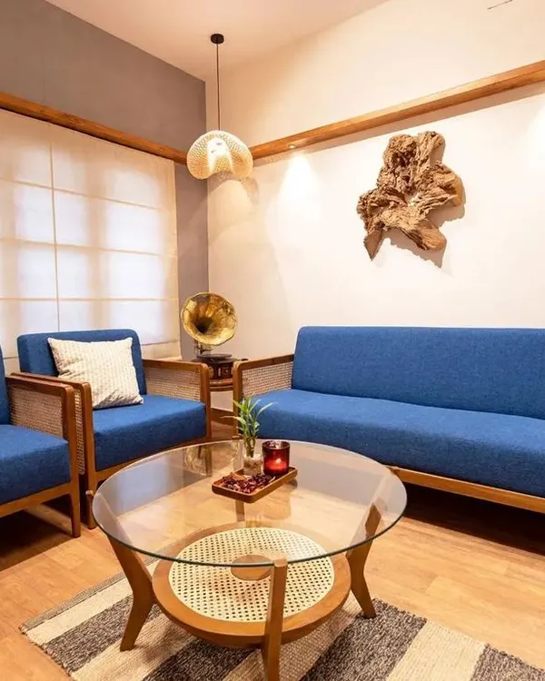 This complete living room set, featuring a five-seater sofa and matching armchairs in a striking blue fabric, shows how I blend classic teak and rattan construction with modern comfort. The glass-topped coffee table adds a final touch of elegance.
