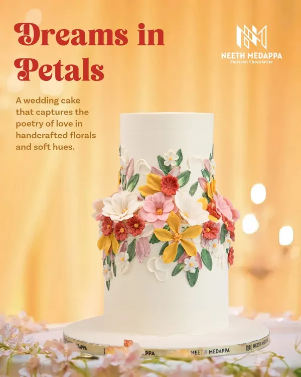 This wedding cake, 'Dreams in Petals', captures the poetry of love with a wreath of handcrafted sugar flowers in soft, romantic hues. The design is a celebration of nature's beauty, perfect for a garden wedding.
