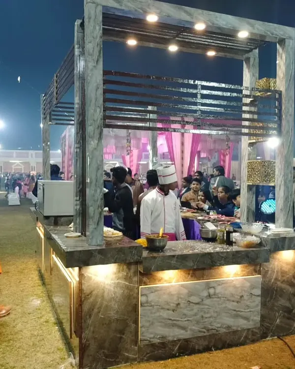My modern live food station in action at an outdoor night event. A chef prepares fresh dishes for guests, who can be seen enjoying the interactive experience.