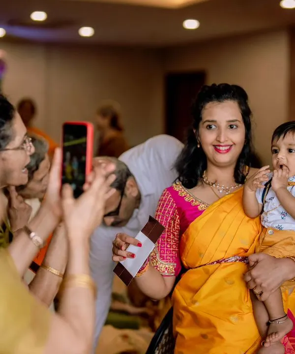 Everyone wants a picture of the little star. I love capturing these candid moments at events like naming ceremonies, where the whole family is celebrating together.