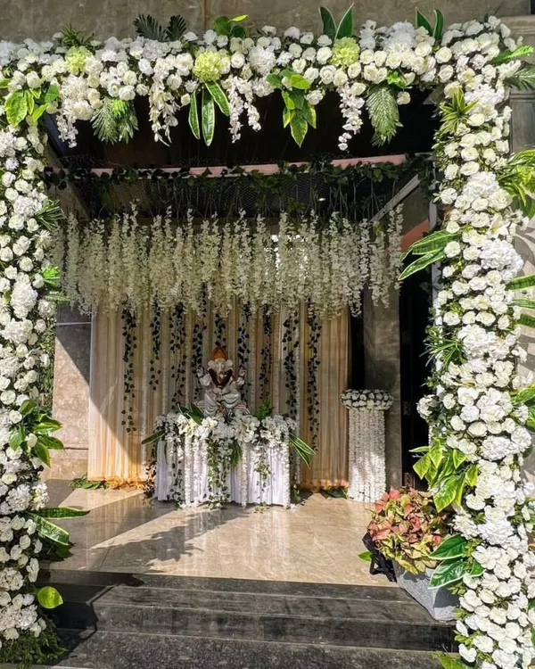 We designed this breathtaking all-white floral mandap to create a serene and heavenly abode for Ganpati. The structure is crafted with dense white carnations and cascading floral strings, offering a truly grand and memorable celebration space.