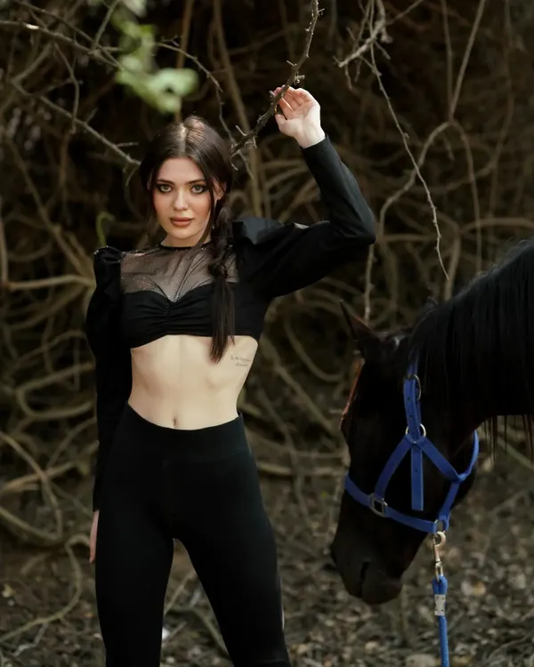 A model poses with one of my black horses during a professional fashion photoshoot at our facility.