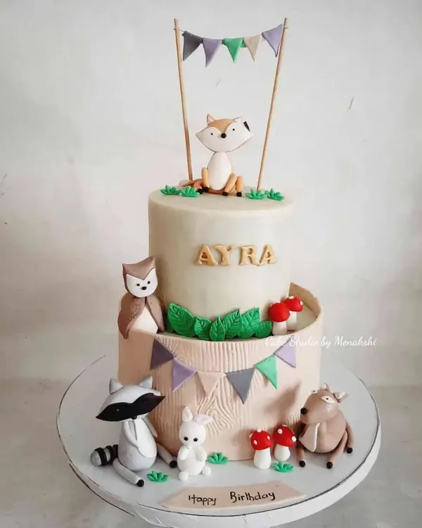 A stunning two-tier woodland animal cake for a first birthday. I loved creating the sweet, handcrafted fox, raccoon, owl, and deer to bring this gentle forest scene to life.