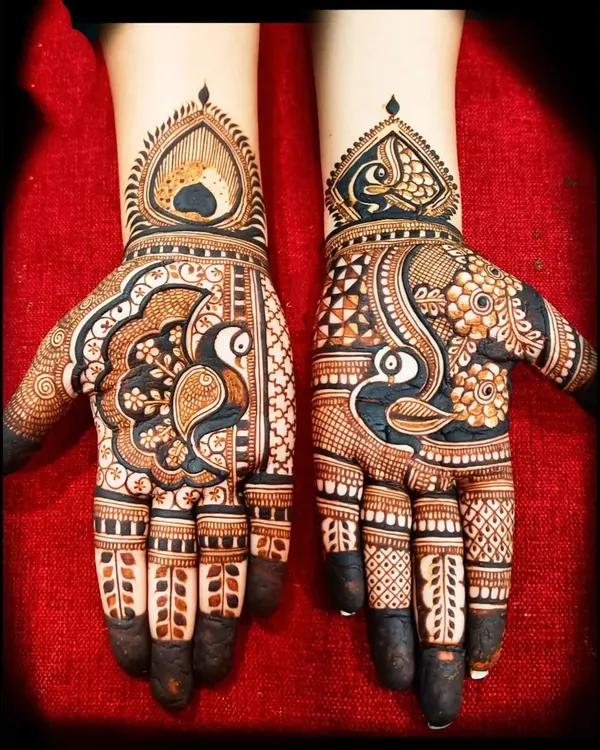 A striking example of Rajasthani art with bold peacock motifs. The contrast between the dark-filled figures and the delicate patterns on the fingers makes this design stand out.