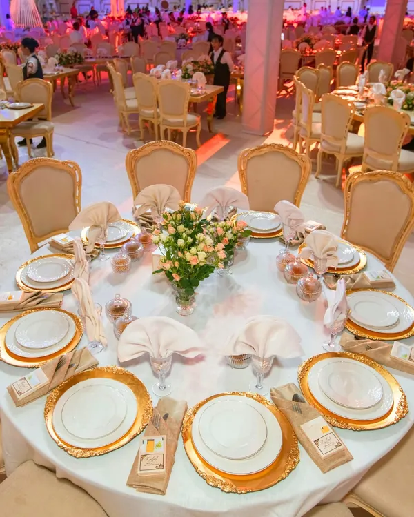 A view of a breathtaking wedding setup we curated. The grand table arrangement with gold accented chairs and pristine white linens creates an atmosphere of pure luxury and sophistication, perfect for a high end celebration.