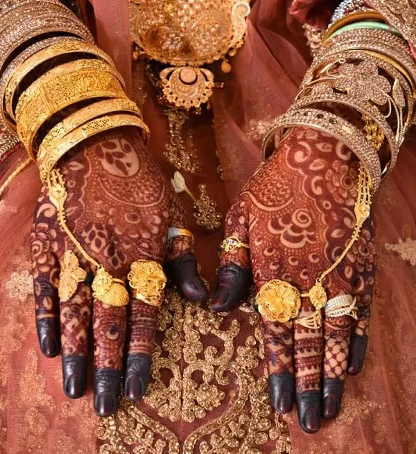 This is the result of my natural henna after the paste has been removed. The deep, rich color on the bride's hands, adorned with gold jewelry, is completely natural. No filters are ever needed.