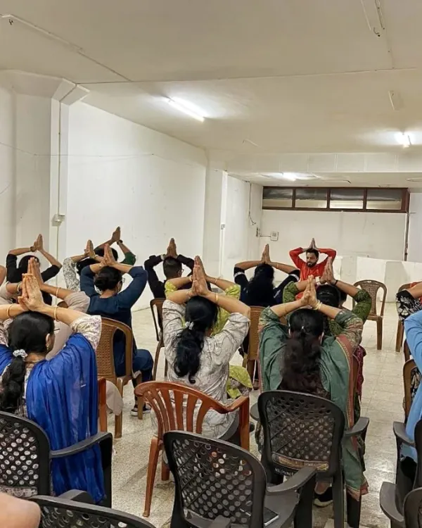 We guide employees through chair yoga postures during a session at National Insurance. These exercises are specifically designed to be performed at a desk, helping to release tension in the neck, shoulders, and back caused by prolonged sitting.