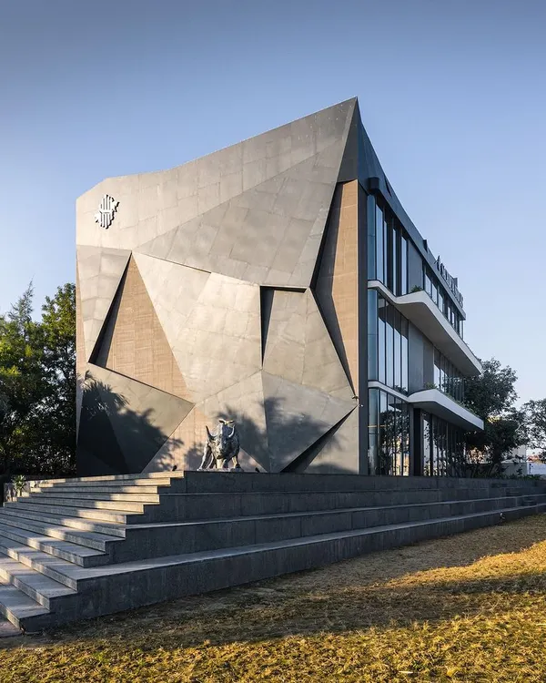 This office building in Hoshiarpur, designed for a financial firm, features a faceted, edgy facade inspired by a black diamond. The sharp, aggressive lines and the prominent bull sculpture symbolize the ambition and volatility of the financial markets, creating a structure with a powerful narrative.