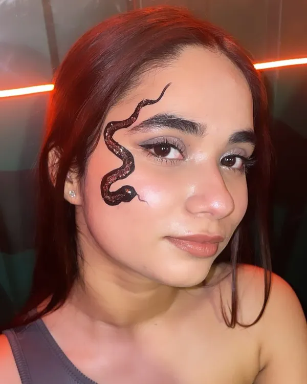 This freehand black glitter snake tattoo is one of my signature looks. It's an edgy and detailed piece of body art that shows how we can create something truly unique for your event.