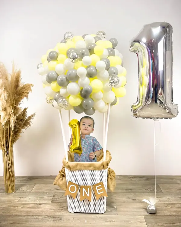 **Hero Item.** A creative first birthday photoshoot featuring a hot air balloon theme. I provide custom props and backdrops like this to make your child's milestone session truly unique and memorable.