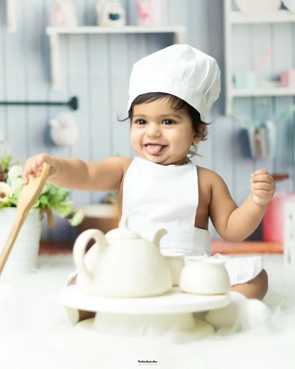 Our little chef is ready to cook up some fun. This themed photoshoot captures a baby's playful side with a chef hat and kitchen props.
