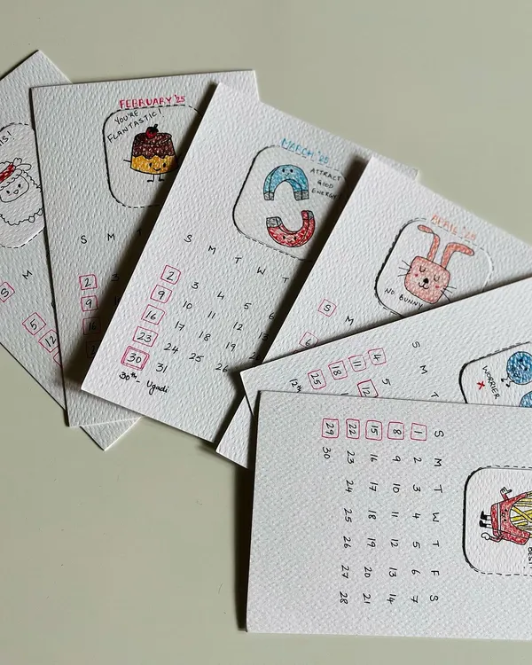 A first look at the pages for the 2025 calendar, fanned out to show the different hand-drawn illustrations. Each one is a little piece of art.