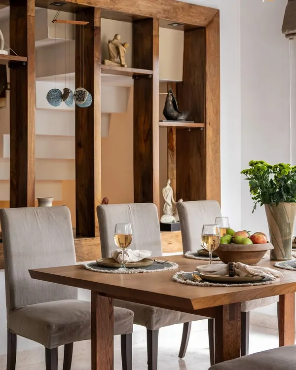 Comfort served with craftsmanship. This dining space features a solid wood table and a built-in shelving unit that acts as both art and architecture, showcasing handpicked accents that echo the room's quiet sophistication.