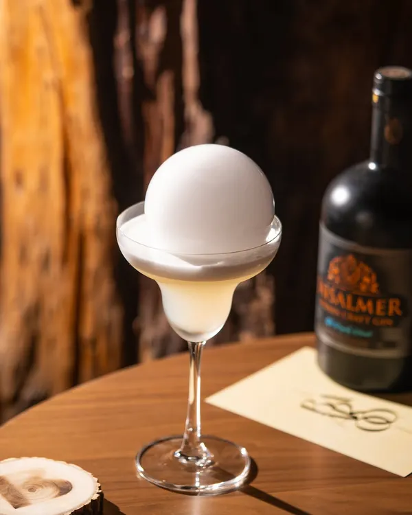 The moment before the magic. This gin cocktail with a smoke bubble is all about building anticipation, a perfect shot for a dramatic social media reveal.