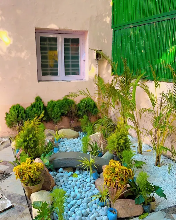 The finished look of a compact Zen garden. This design uses a dry river of white pebbles, smooth rocks, and small shrubs like Juniper to create a peaceful scene that requires very little maintenance.