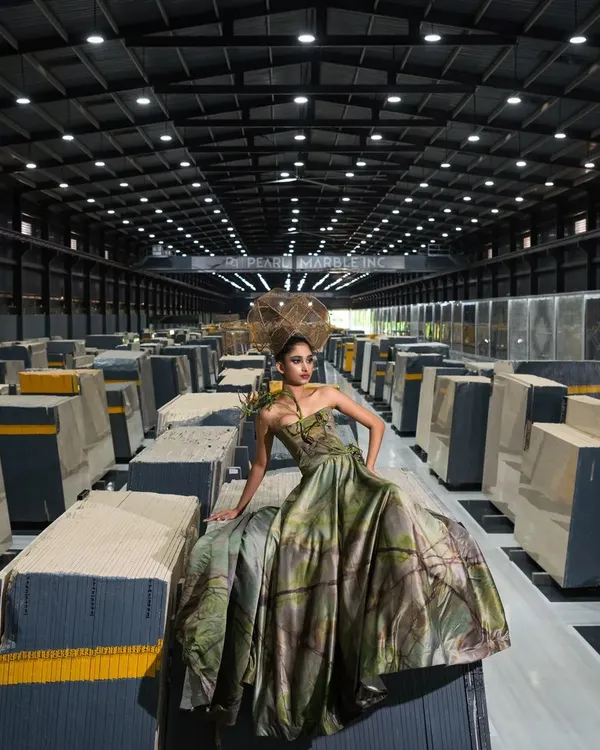 A wide shot from the marble factory campaign, showing the scale of the industrial environment. Placing the model in this vast space creates a striking contrast and a sense of grandeur, perfect for a high-impact editorial.