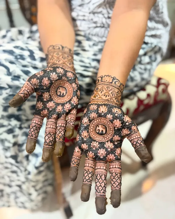 This design features a central mandala with a lucky elephant motif, surrounded by lotus patterns. The dark, filled-in background makes the main design really stand out.