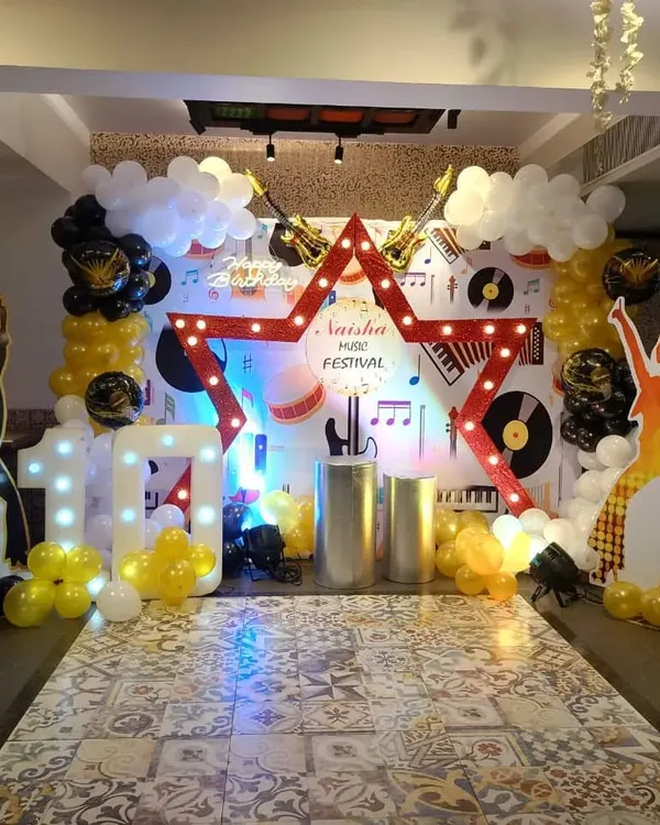 For this musical-themed birthday, we provided a complete package. The decor included a large star-shaped marquee light and musician silhouettes, and we also arranged for various activity stalls.